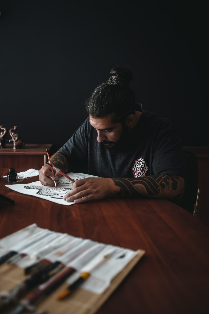 BOGA tattoo artist sketching custom geometric tattoo design for Oakland Bay Area client